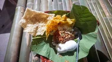 Meşe yaprağı tabanlı Pecel pilavı. Geleneksel bambu masasında bulunan tipik bir Java, Endonezya besin tezgahı.