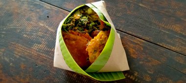 Kapalı bir manzara hasadı kutlamak için mübarek bir pirinç menüsü pirinç, erişte, kaju yaprağı, baharat, ızgara tavuk ve muz yapraklarına sarılmış kızarmış yiyecekten oluşan geleneksel bir tarz.