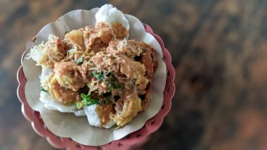 Kerupuk pekeli haşlanmış sebze, tapyoka unundan yapılmış kraker buğulanmış sebze ve baharatlı sambel pekel, ahşap masa.