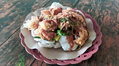 Kerupuk pekeli haşlanmış sebze, tapyoka unundan yapılmış kraker buğulanmış sebze ve baharatlı sambel pekel, ahşap masa.