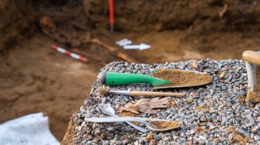 Arkeolojinin basit araçları. Spatula, fırça, kaşık. Arkeolojik kazılar. İnsan kalıntıları, iskelet kemikleri ve mezardaki kafatasları. Zilaiskalns, Valmiera.