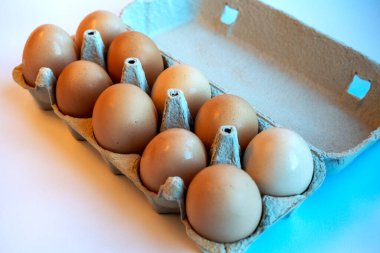 Kağıt tepside on kahverengi yumurtaya yakın çekim. Yumurtalar vitamin, fosfor, çinko ve bol miktarda kolin içerir. Geri dönüşümlü malzemeler için yumurta kabı