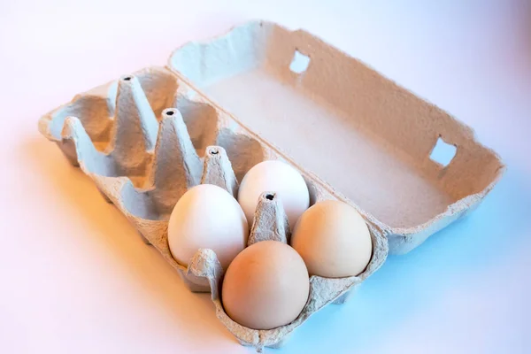 新鲜的两个浅褐色和两个白色的鸡蛋在一个纸盒和六个空的空间健康的食物 可回收物料制成的蛋盒 — 图库照片