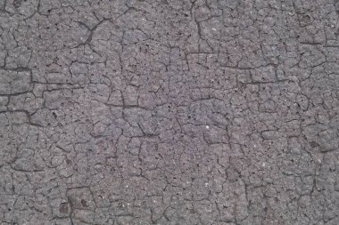 Eskimiş gri ruberoid doku, sayısız çatlaklar ve çatlaklar, arka plan olarak güneş yanığı yüzeyi kullanılıyor..