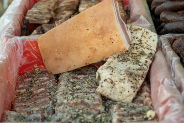 Büyük parça tuzlu pastırma. Geleneksel Ukrayna tariflerine göre. Kırsal pazarda el yapımı ticaret.