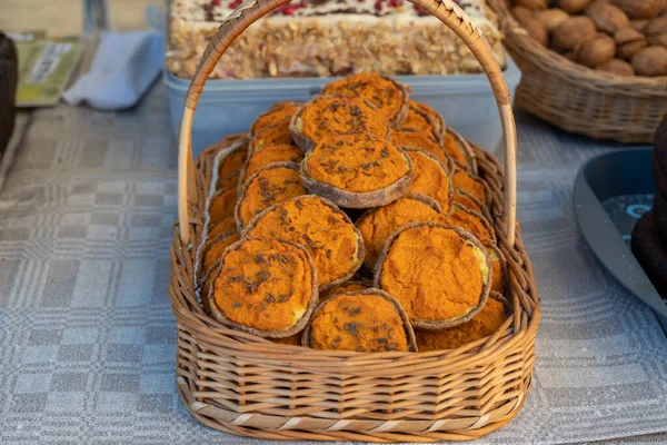 A full wicker basket. Rye Latvian dessert Sklandrausis with carrot paste, potatoes and cumin, handmade. A full wicker basket. Homemakers\' Market