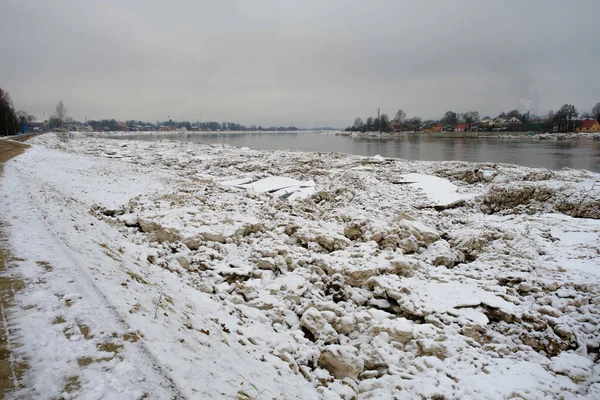 Jekabpils after the flood. River Daugava with ice piles on the banks. A dark, dreary January day.