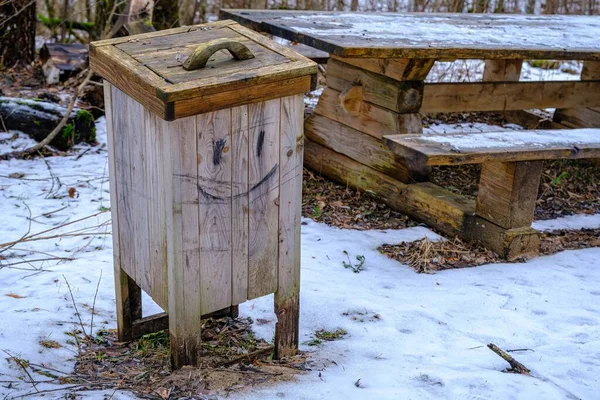 A wooden waste bin in nature. Clean environment in nature. Urn with opening lid.