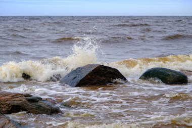 The waves of the Baltic Sea wash the stones of different sizes on the shore