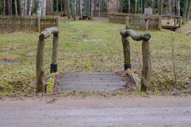 An old wooden bridge over a small ditch in spring. Outdoor park design and interior
