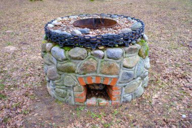 idyllic outdoor barbecue area - built with flat stones campfire place. For public use