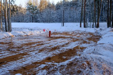 New road construction site in the forest in winter with snow and mud. Construction of new communications.