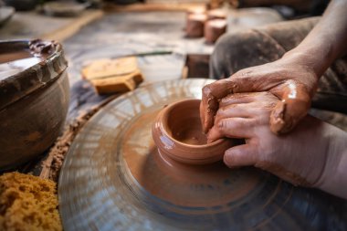 seramik, atölye, seramik sanat konsepti - yeni bir kap oluşturan insanın ellerinin yakın çekimi, insanın parmakları çömlekçi çarkı ve ham kenar, ön yakın plan