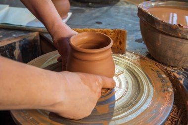 seramik, atölye, seramik sanat konsepti - yeni bir kap oluşturan insanın ellerinin yakın çekimi, insanın parmakları çömlekçi çarkı ve ham kenar, ön yakın plan
