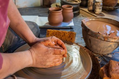 seramik, atölye, seramik sanat konsepti - yeni bir kap oluşturan insanın ellerinin yakın çekimi, insanın parmakları çömlekçi çarkı ve ham kenar, ön yakın plan