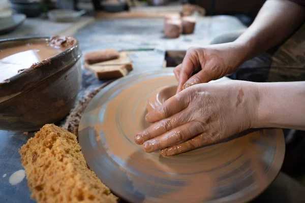 stock image ceramics, workshop, ceramic art concept - close-up of man's hands forming a new vessel, man's fingers working with potter's wheel and raw edge, frontal close-up