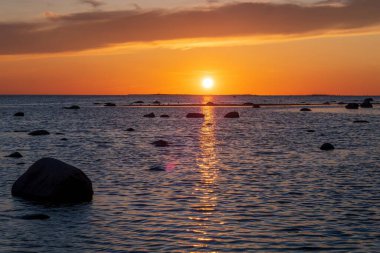 Deniz yüzeyinin altında büyük sarı güneşli parlak gün batımı