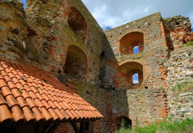Eski bir ortaçağ kalesinin duvarları. Çöken duvarlar korunmuş. Turistler için gezi objesi. Duvardaki delikleri çatlatmış. Tuğla duvar bina ya da ev yıkıldı. Eski binalar. Letonya Bauska Kalesi