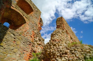Eski bir ortaçağ kalesinin duvarları. Çöken duvarlar korunmuş. Turistler için gezi objesi. Duvardaki delikleri çatlatmış. Tuğla duvar bina ya da ev yıkıldı. Eski binalar. Letonya Bauska Kalesi