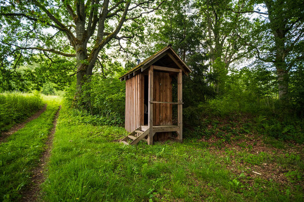 wooden outdoor toilet in the forest. Toilet at the tourist trail.