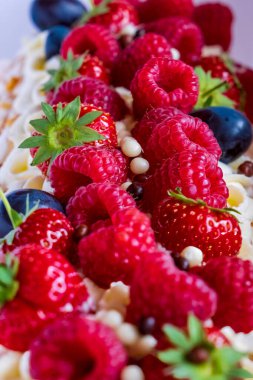 Kremalı ve taze böğürtlenli Pavlova pastasını yakından çek: yabanmersini, ahududu, çilek