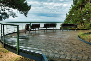 Peipus Gölü 'ne bakan ahşap bankların olduğu ahşap bir platform manzarası. Kumsal.