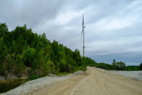 这是一个以前的页岩采石场 有碧水和风景如画的山丘 不像纳尔瓦页岩安置池 一个漆黑的秋日爱沙尼亚 艾杜采石场 远处的一个高大的风力涡轮机 — 图库照片
