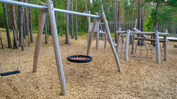 Empty children\'s playground in the park. Ecological children\'s park. Wooden structures.