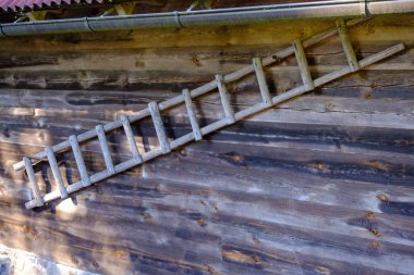 Eski ahşap evin duvarındaki ahşap merdivenler. Letonya çiftliği.