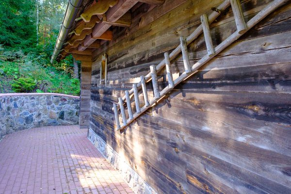 Деревянная лестница у стены старого деревянного дома. Латвийское хозяйство.