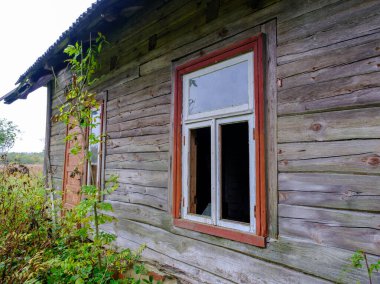 Letonya 'nın kırsalında terk edilmiş eski ahşap bir kır evi..