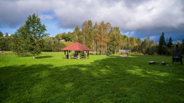 Wooden gazebo, resting place in the park. Equipped with wooden tables and benches.