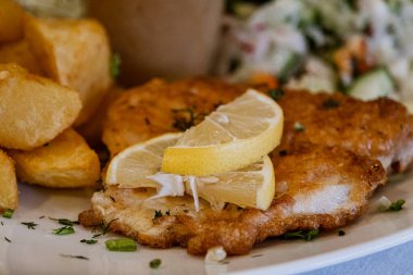 Kızarmış patates ve bir dilim limon. Balık un içinde kızarır..