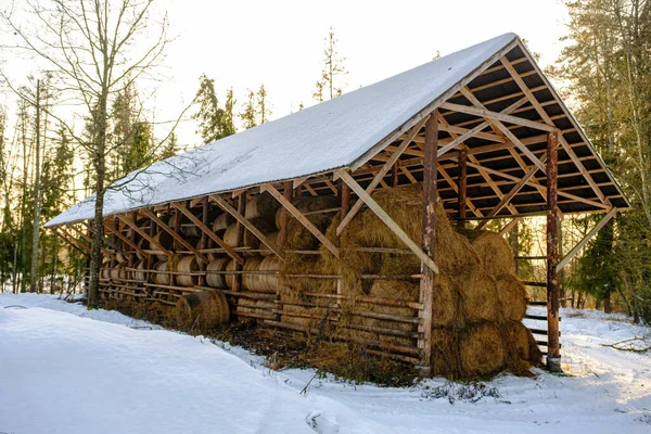 Large hay barn with hay rolls. Open type hay storage building.
