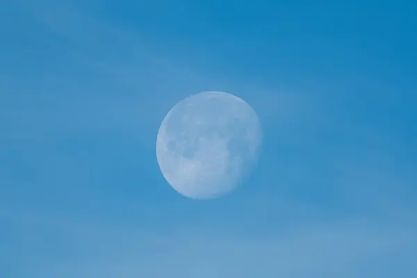 Açık mavi gökyüzünün arka planına karşı gündüz görülebilen parlak ve detaylı bir uydu, sakin bir atmosfer yaratıyor..