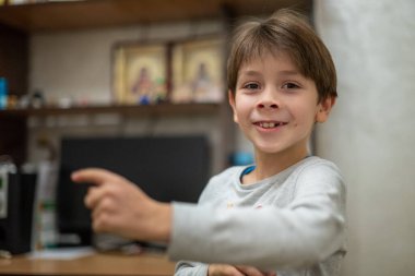 Head shot of healthy kid, Portrait happy child looking at camera with smiling face, candid shot cute little boy relaxing stay at home during covid lock down.Positive children concept, Social distancing.