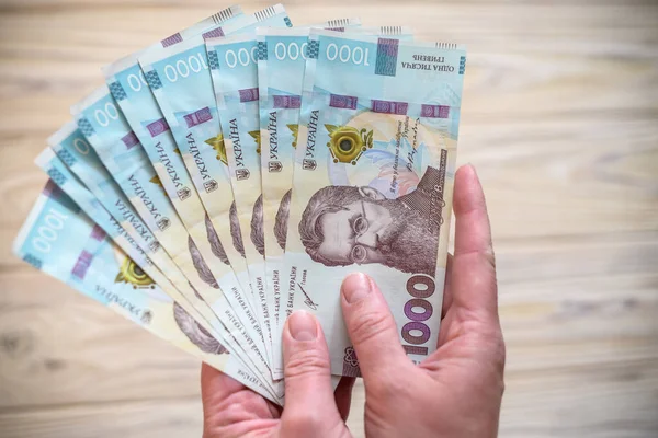 Dinero Ucrania Montón Billetes Hryvnia Ucranianos Las Manos Mesa Madera Imagen De Stock