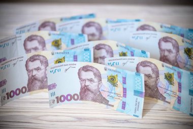 Beyaz arka planda 1000 Ukrayna parası Hryvnia 'yı kapatın. Metin için fotokopi alanı olan bir iş alanı yatıyordu. Kriz ve mali çalkantı, enflasyon, devalüasyon, ekonomik depresyon sorunu.