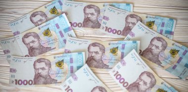 Beyaz arka planda 1000 Ukrayna parası Hryvnia 'yı kapatın. Metin için fotokopi alanı olan bir iş alanı yatıyordu. Kriz ve mali çalkantı, enflasyon, devalüasyon, ekonomik depresyon sorunu.