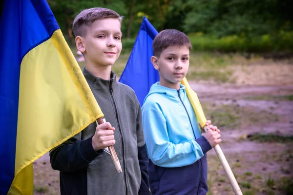 两个男孩手中拿着乌克兰国旗 孩子们在风中摇曳着乌克兰国旗 乌克兰独立日 卖旗日 — 图库照片