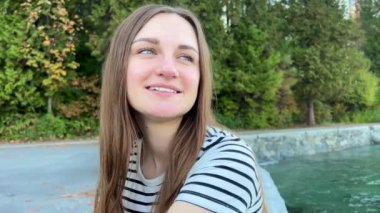 25 yaşındaki genç bir kız oturur ve şaşırır. Ağzını kocaman açar ve gözleri açılır. Açık kahverengi saçları vardır.