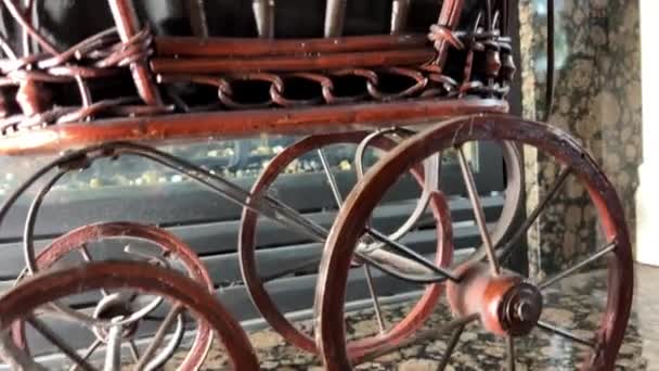 在壁炉的背景下 柳条车是玩具般的艺术小轮子 就像推车上的玩具一样 它在景色中间的壁炉织物周围微微恐吓着褐色的木头和大理石瓷砖 — 图库视频影像