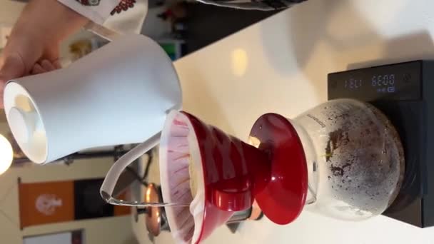 コーヒー醸造ドリッパーのための明るい赤いカップは 最小限の近代的なカフェで代替の専門フィルターコーヒーを作ります バリスタがコーヒーでドリンクを作ります — ストック動画