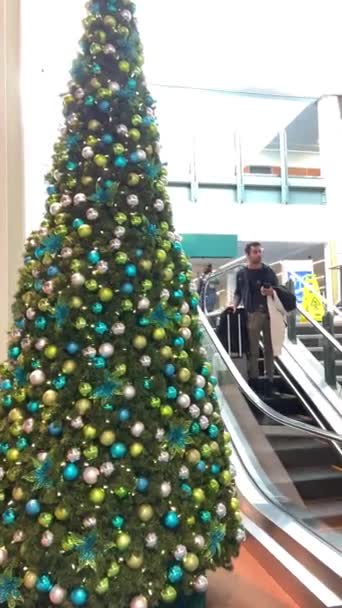 Yvrバンクーバー空港異なる航空会社での新年のフライト人々はエスカレーターを降りて一日に乗り込みます木は多くのおもちゃやクリスマスボールで飾られています18 2022カナダ — ストック動画