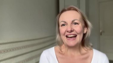 Kadın iyi haberler alır ağzını açar ve ellerini çırpar mutlu kaşları yükselir ve yüzünde haz duyar elleri ve kahkahalar atar ürün reklamını kazanmak gerçekten çok mu şanslıdır