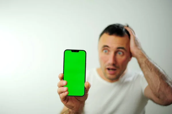 Adulto Homem Telefone Verde Tela Chromakey Surpreendido Segurando Mão Atrás — Fotografia de Stock