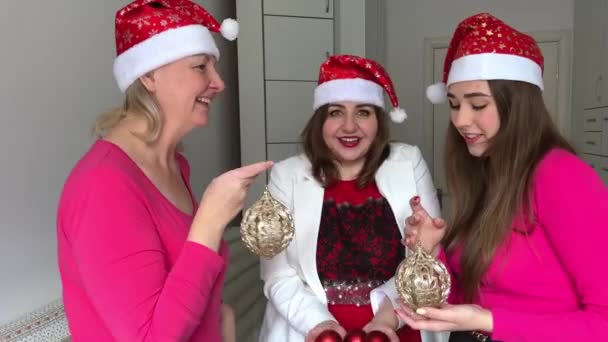 三个女人手里拿着圣诞树玩具庆祝新年派对交流爱情友谊一个女人从圣诞树上吐出红球 — 图库视频影像