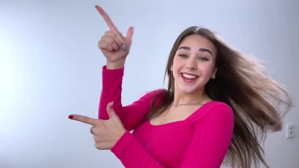 Delicesine Güzel Bir Kız Beyaz Arka Planda Bir Şeyin Reklamını — Stok video
