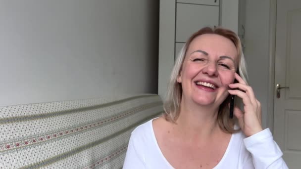 Γυναίκα Που Μιλάει Στο Κινητό Τηλέφωνο Στο Σπίτι Χαρούμενη Μεσήλικη — Αρχείο Βίντεο