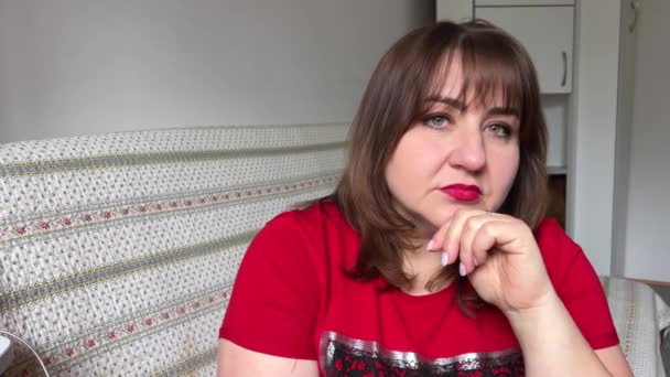 Ciddi Düşünceli Bir Kadın Yaşında Kırmızı Tişörtlü Koluna Yaslanmış Kameraya — Stok video